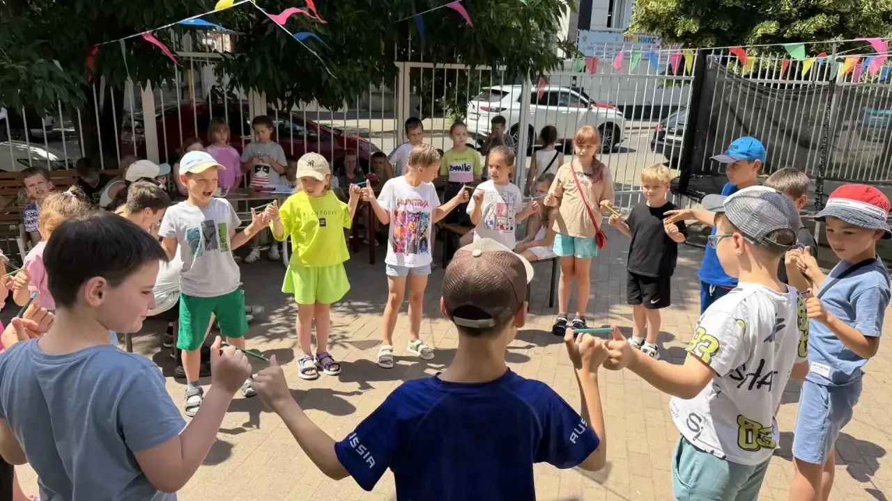 Дети играют и веселятся на прогулке в летнем клубе «Карандаш»